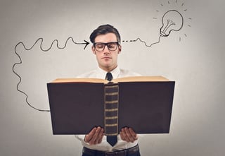 Photo of smart businessman reading a big book