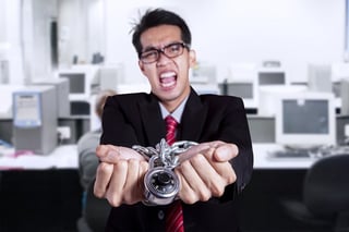 angry businessman handcuffed by IT debt