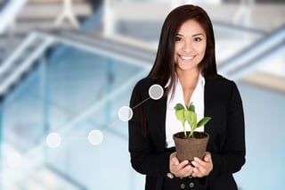 Photo of businesswoman nurturing a seedling