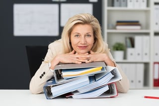 Photo of businesswoman with a stack of binders